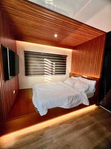 a bedroom with a large bed with a window at Cozy Tiny Home with Outdoor Hot Tub in City Center in Davao City