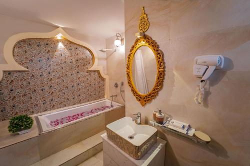 a bathroom with a sink and a mirror at The Neeraj Ganga Heritage Palace in Rishīkesh