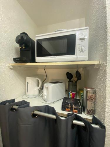 a microwave sitting on top of a shelf at Studio Centre Port avec piscine résidence Port Richelieu in Cap d'Agde