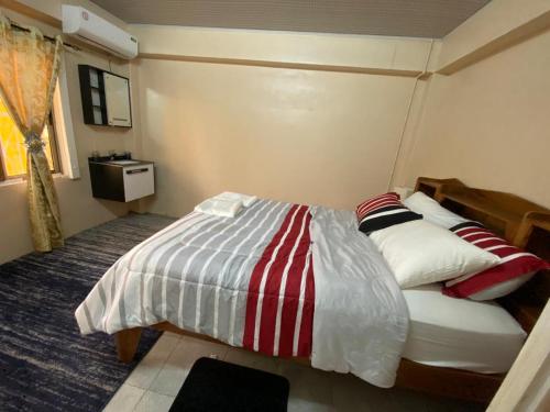 a bedroom with a bed with red and white stripes at Destination Hope Booking in Georgetown