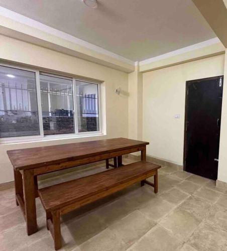 Monkey Temple Apartment في كاتماندو: مقعد خشبي في غرفة مع نافذة