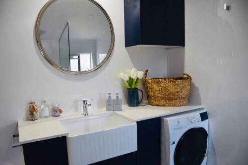 un baño con lavabo y espejo en Pet Friendly Beach House with pool - Sleeps 10, en Urangan