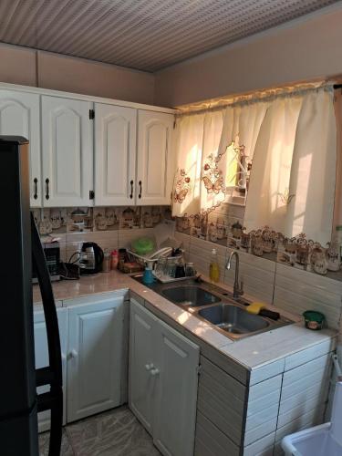 a kitchen with white cabinets and a sink at Destination Hope Booking in Georgetown