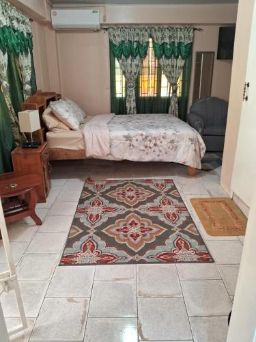 ein Schlafzimmer mit einem Bett und einem Teppich auf dem Boden in der Unterkunft Destination Hope Booking in Georgetown