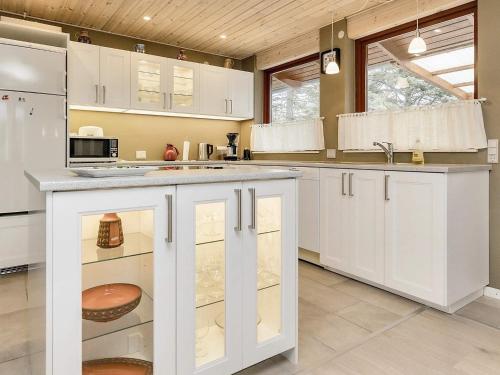 a kitchen with white cabinets and a counter top at 6 person holiday home in R dby in Rødby
