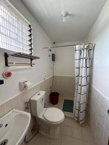 Baño pequeño con aseo y lavamanos en Caishen Modern Affordable Apartelle 302, en Silang