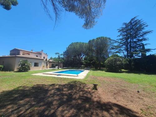 une maison avec une piscine dans une cour dans l'établissement La Villa des Pins avec piscine et tennis, à Garons