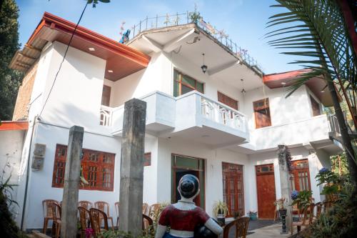 una estatua de una mujer sentada frente a una casa en Golden Holiday Home, en Arambegama