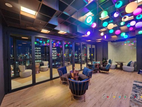 a bar with chairs and tables in a room at Edge Central Pattaya by JJJ in Pattaya Central