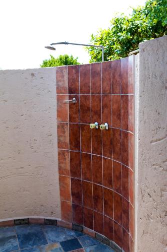 a tiled shower in the side of a wall at Thaba Legae Guest Lodge in Rustenburg