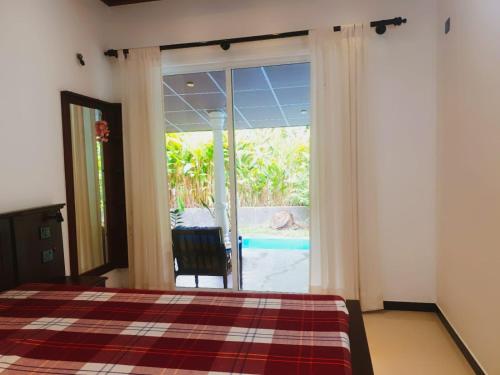 a bedroom with a bed and a view of a pool at Happy Three Holiday Homes in Hikkaduwa