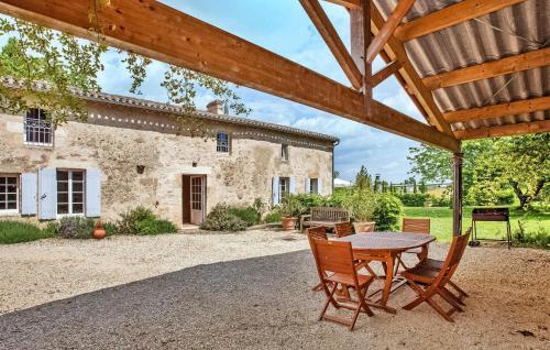 un patio avec une table et des chaises devant un bâtiment dans l'établissement La Fleur Godard, à Saint-Cibard