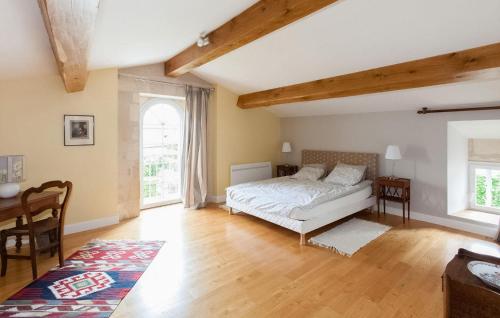 1 dormitorio con cama, escritorio y ventana en La Fleur Godard, en Lussac