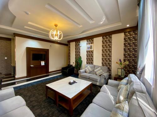 uma sala de estar com um sofá e uma mesa em Aral Hotel Apartments em Tabuk