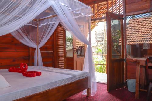 Un dormitorio con una cama con una cinta roja. en Mr Fisherman, en Arugam Bay