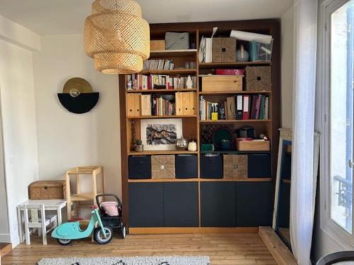 une chambre avec une étagère et un scooter dans l'établissement Le Pavillon Bleu, à Nanterre