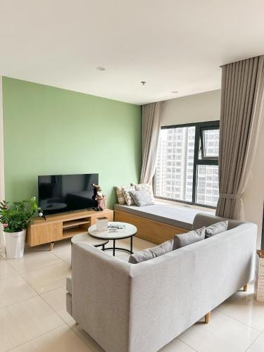 a living room with a couch and a tv at Bunny Bliss-Service Apartment in Hanoi