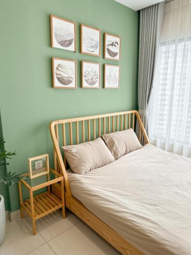 a bed in a bedroom with a green wall at Bunny Bliss-Service Apartment in Hanoi