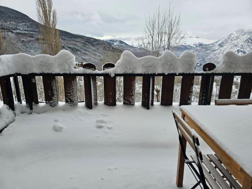 a fence covered in snow next to a bench at Tuhogarencerler parking y taquilla en pistas in Cerler