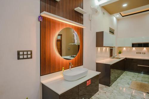 a bathroom with a sink and a mirror at Thalir Resort in Alleppey