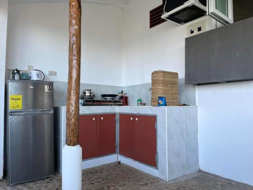 a kitchen with red cabinets and a stainless steel refrigerator at Casa Leonardo in Bacungan