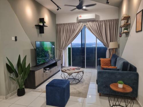 a living room with a blue couch and a tv at ZIYAD AL KHAYR HOMESTAY in Kajang