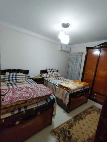 sypialnia z 2 łóżkami i komodą w obiekcie شقه فندقيه بالإسكندرية w Aleksandrii
