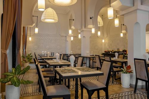 a restaurant with tables and chairs in a room at The Wander by Sarai in Siem Reap