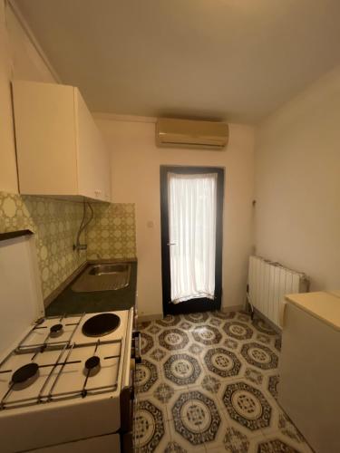 a small kitchen with a stove and a window at Home Vibe in Sukošan