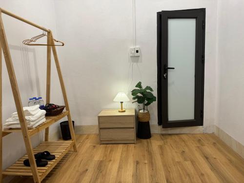 a room with a door and a table with a lamp at Cao Bằng Siu homestay in Hoàng Ngà
