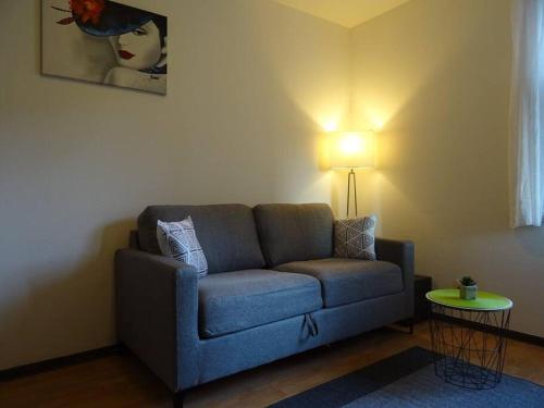 a living room with a blue couch and a lamp at Le Zen in La Ciotat