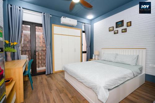 um quarto com uma cama, uma secretária e uma janela em JOY APARTMENT TAY HO em Hanói