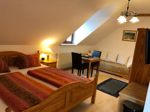 a bedroom with a bed and a desk with a laptop at Landhaus zur Therme in Jennersdorf