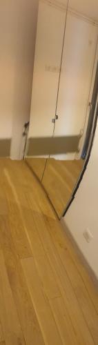 an empty room with a wooden floor and a mirror at Magnifique appartement rénové avec terrasse in Guyancourt