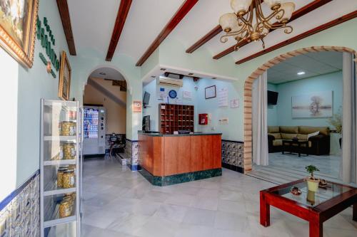 un hall d'une pharmacie avec un comptoir et une table dans l'établissement Hotel Chamizo, à El Arahal