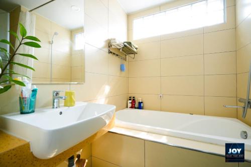 La salle de bains est pourvue d'un lavabo et d'une baignoire. dans l'établissement JOY APARTMENT TAY HO, à Hanoï