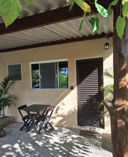 a picnic table in front of a house at Chapéu de Sol - Área Gourmet, TV, Internet, Roupas de Cama e Banho, Jardim, Horta e Pomar in Ilha Comprida