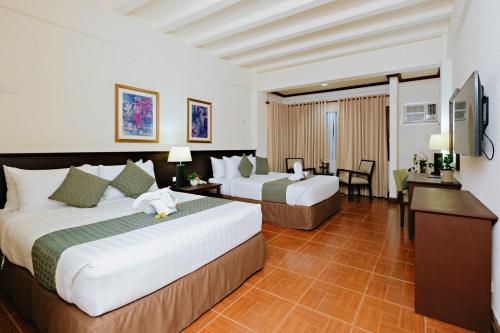 um quarto de hotel com duas camas e uma televisão em The Suites At Mount Malarayat em Lipa