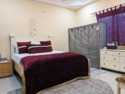 a bedroom with a large bed and a dresser at Coun Rapids in Brufut