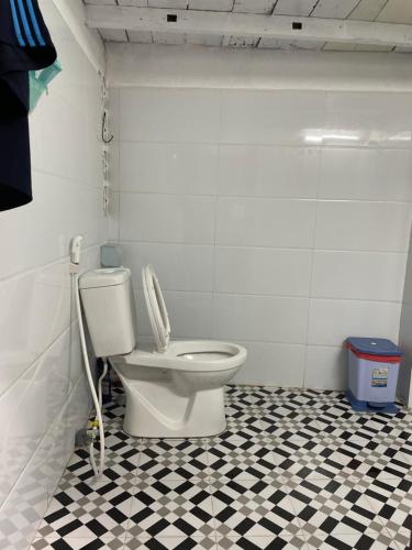 a bathroom with a toilet and a black and white tile floor at Cọ cùn homestay/ Handmade/ Artwork (2 beds) in Buon Ma Thuot