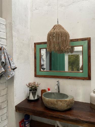 a bathroom with a stone sink and a mirror at Cọ cùn homestay/ Handmade/ Artwork (2 beds) in Buon Ma Thuot