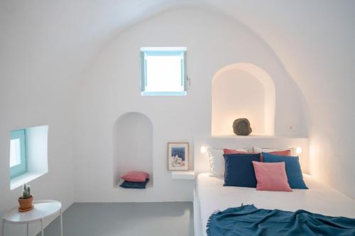 una camera bianca con un letto e una finestra di Vima Santorini, Traditional Luxury a Emporio
