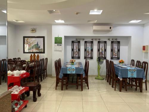 a dining room with two tables and chairs with blue tables at Tuan Long Hotel in Ho Chi Minh City