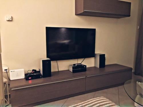 a flat screen tv sitting on top of a entertainment center at Home Sweet Home! in Volos