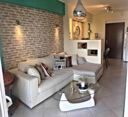 sala de estar con sofá y pared de ladrillo en Home Sweet Home!, en Volos