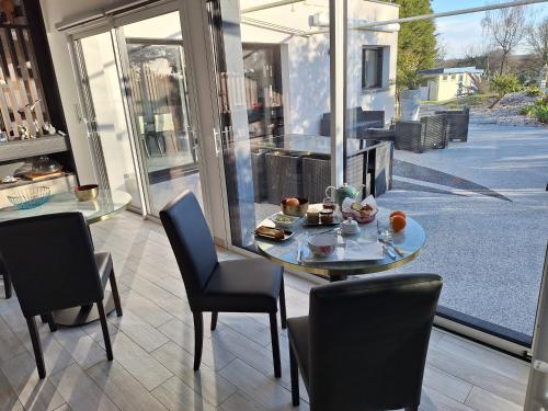 a dining room with a table and chairs and a window at MOR-HA-MARCH Chambres d'Hôtes in Sarzeau
