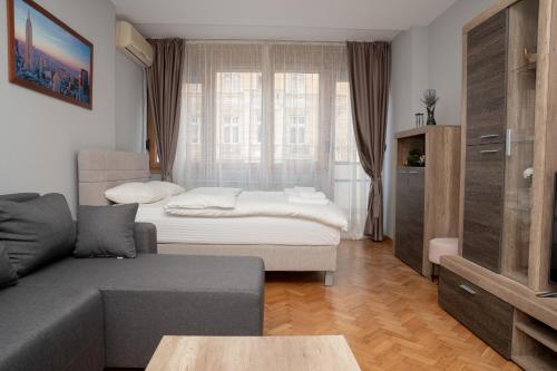 a living room with a couch and a bed at Tommy Apartment in Belgrade