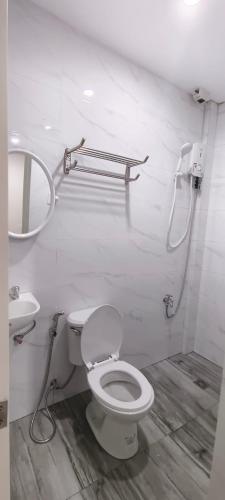 a white bathroom with a toilet and a sink at CASA VICTORIA PENSION HOUSE TANDAG CITY -Vassilis in Somosomo