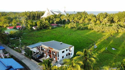 an aerial view of a house on a hill with palm trees at CASA VICTORIA PENSION HOUSE TANDAG CITY -Vassilis in Somosomo