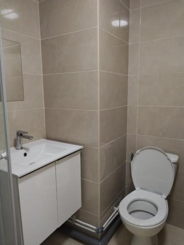 une salle de bain avec des toilettes blanches et un lavabo dans l'établissement Studio meublé proche Métro JO24, à Noisy-le-Sec